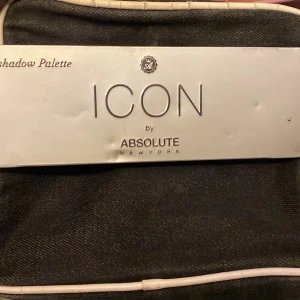 Ögonskuggspalett från Absolute New York - Säljer en ögonskuggspalett från Absolute New York med namnet ICON. Paletten innehåller flera nyanser från neutrala till skimrande toner. Perfekt för att skapa både vardagliga och festliga looks. Inkluderar en dubbelsidig borste för enkel applicering.