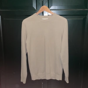 Beige tröja från Selected Homme - Säljer en stilren beige tröja från Selected Homme i merinoull. Tröjan har en klassisk design med rund hals och långa ärmar. Perfekt för en elegant och bekväm look.