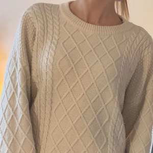 Beige stickad tröja - Säljer en mysig beige stickad tröja med ett klassiskt flätmönster. Supermysig på vinter/höst, lite Rory Gilmore vibe. Säljer pga att jag inte använder längre.