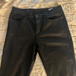 Svarta byxor från Vero Moda - Snygga svarta läder byxor från Vero Moda . Midwaist, Används fårtal gånger. De sitter jätte fint och är bootcut. Nypris 700