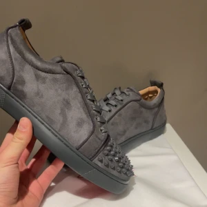 Gråa Christian Louboutin med spikar - Säljer dessa tvär feta Loubs i färgen grå! Skorna är i NY SKICK! Skorna är i storlek 42 och är perfekta inför sommaren! Dustbag medföljs och KVITTO finns! Vid minsta lilla fundering hör av dig till mig!🥂