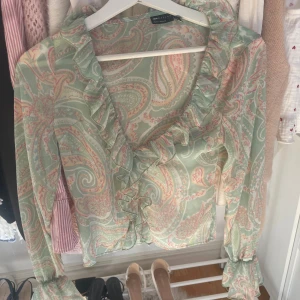 Mönstrad blus  - En grön/rosa blus med volang från asos. Perfect till sommaren. Inte använd mycket alls.