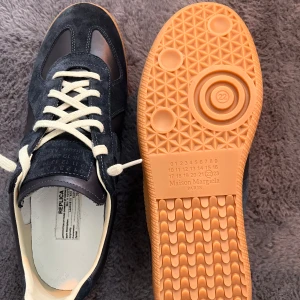 Marinblå sneakers från Maison Margiela - Maison Margiela Gats.(Marinblå)                                                          10/10 skick.                                                                                 Perfekta för en trendig look. Box och dustbags ingår! Kvitto finns.