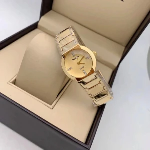 Guldfärgad klocka från Rado - Elegant guldfärgad klocka från Rado med en stilren design. Klockan har en glittrig urtavla och länkar i guldton. Perfekt som en lyxig accessoar för speciella tillfällen.