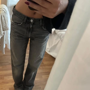 Grå jeans Zara - Säljer ett par grå jeans med låg midja och klassisk femficksdesign. Jeansen har en rak passform och är perfekta för en avslappnad stil. De har en knapp och dragkedja framtill. Jeansen är från Zara, knappt använda 😇