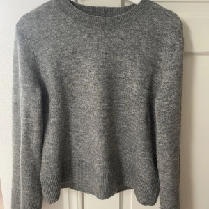 Grå tröja från H&M - Säljer en grå stickad tröja från HM. Aldrig använd och i perfekt skick. Den går in i midjan lite på ett snyggt sätt. Skriv vid intresse eller köp direkt!💕