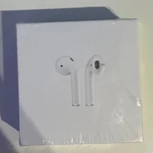 Air-  pods 2 gen - Air- pods 2 gen plastet är rivet på en den högra sidan men annat så är den helt oöppnad/ oanvänd 