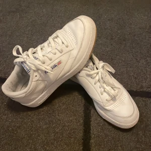 Vita sneakers från Reebok - Säljer ett par klassiska vita Reebok sneakers med snörning och gummisula. Perfekta för en stilren look. Köpta helt nya och endast använda typ 5 gånger! Stl 41