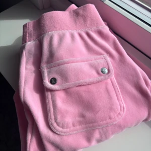 Juicy couture byxor  - Juicy couture byxor med praktiska fickor och knapplås. Byxorna har en bekväm passform och är perfekta för en avslappnad stil. De har en elastisk midja och är gjorda i ett mjukt material för extra komfort. Pris går att diskutera.❤️