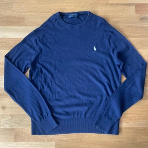 Mörkblå tröja från Ralph Lauren - Säljer en stilren tunn mörkblå tröja från Ralph Lauren, perfekt nu inför sommaren. Priset kan diskuteras vid snabb och smidig affär.