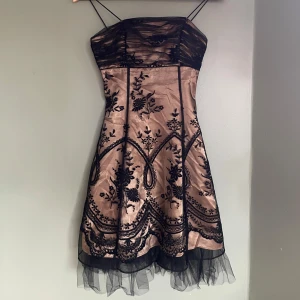 Svart och senapsgul klänning från Morgan & Co - Min favoritklänning från Morgan & Co i senapsgul färg med svart broderi och tyllkant. I storlek 1/2 men är för liten för mig som brukar kunna ha xs, så jag skulle säga att den är xxs! Använd fåtal gånger och i perfekt skick!