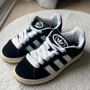 Svarta Adidas campus 00s - Säljer adidas campus 00s. Använda endast ett fåtal gånger och är i väldigt fint skick. Passar absolut till de mesta i klädesväg. 