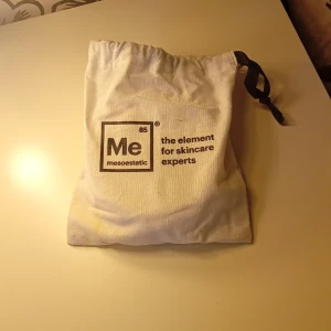 Rengöringspads från Mesoestetic - Två runda rengöringspads i vitt tyg från Mesoestetic, perfekta för att ta bort smink eller applicera toner. Kommer i en praktisk tygpåse med dragsko och svart band. Padsen har en mjuk yta och en liten etikett med varumärket. Helt ny så aldrig använd 