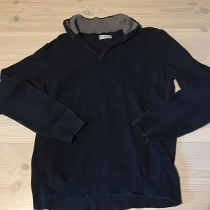 Mörkblå halvzip med dragkedja från Mango - Säljer en mörkblå halvzip/quarterzip tröja från Mango med dragkedja framtill. Insidan av kragen är ljusgrå vilket ger en snygg kontrast. Perfekt för lager-på-lager och enkel att matcha! Nypris: 500 Mitt pris: 199