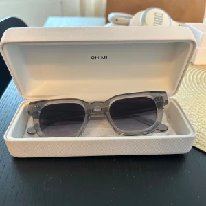 Grå transparenta solglasögon från CHIMI - Säljer ett par solglasögon från CHIMI. Modellen är 04 och färgen grå, kommer med originaletui✨
