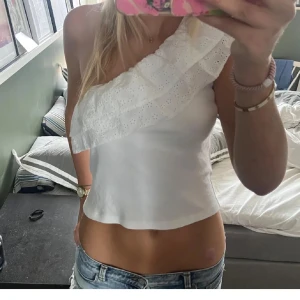 Vit one shoulder topp med volang - Säljer en vit oneshoulder topp från Gina💞 använd fåtal gånger 