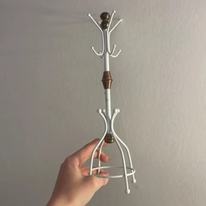 smyckeshållare - en smidig och snygg smyckeshållare i vitt metall med detaljer i guld. Perfekt för att hänga smycken eller små accessoarer på ett snyggt sätt.