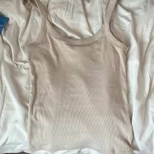 Beige ribbad linnetopp Gina Tricot - Säljer en beige ribbad linnetopp från Gina Tricot. Använd ett fåtal gånger men väldigt bra skick ändå! Pris går att diskutera!❤️
