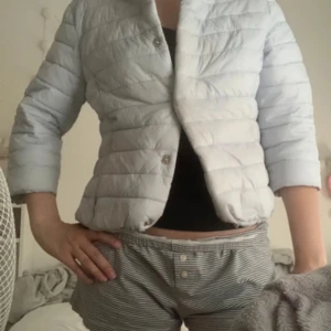 Ljusblå trekvartsärmad jacka - Säljer en ljusblå quiltad jacka med trekvartsärm och knappar. Perfekt för vår och sommar. Jackan har en stilren design och är lätt att matcha med olika outfits.