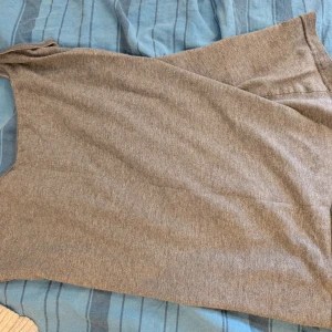 Grå ärmlös linne från H&M Divided - Enkel och stilren grå linne från H&M Divided i storlek 38. Linnet är ärmlös med rund halsringning och har en rak, avslappnad passform. Perfekt för dig som gillar basic och comfy vibes. 