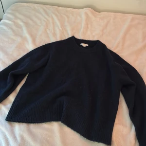 Marinblå stickad tröja från Gina Tricot - Mysig marin blå stickad tröja från Gina Tricot i oversized modell. Tröjan har rund halsringning, långa ärmar och bred ribbad kant nedtill och vid ärmsluten. Perfekt för kalla dagar och enkel att matcha med jeans eller kjol.