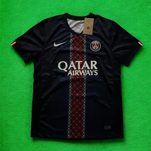 PSG O. Dembélé matchtröja Nike - Paris Saint-Germain fotbollströja med O. Dembélé och nummer 10 på ryggen. Mörkblå med röd och vit grafisk rand mitt på, PSG-emblem och Nike-logga på bröstet. Tillverkad i lätt och ventilerande polyester, perfekt för match eller träning.