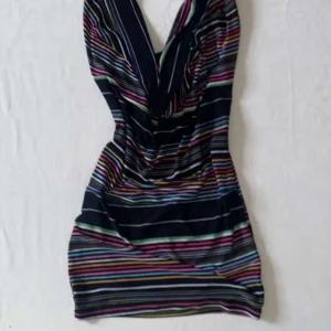 2000s Randig kortklänning  - Snygg kortklänning med färgglada ränder på mörk botten. Djup v-ringning framtill och figurnära passform. Perfekt för dig som vill sticka ut med en lekfull och trendig look.