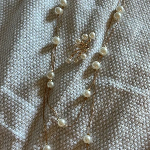 Guldigt pärlset halsband & ring - Säljer ett snyggt smyckeset med ett långt halsband och en statementring i guldton med vita pärlor. Halsbandet har två långa kedjor som är justerbara och ringen är även justerbar!🤍 I jättefint skick, säljer pga att det inte kommer till användning.