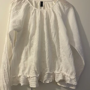 Söt vit blus Vera Moda med brodyr o lång ärm  - Söt vit blus med rund hals o lång ärm. Smockad nederkant. Brodyr både från o bak. Vera Moda. Xl men rätt liten i stl. 