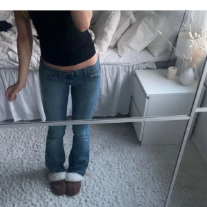 Wrangler bootcut jeans ljusblå - Säljer ett par klassiska blå jeans från Wrangler med bootcut-passform och låg midja. Jeansen har fem fickor, bälteshällor och snygga detaljer på bakfickorna. Perfekta för dig som gillar en tidlös denimlook. Midjemått 36 innerbenslängd 82💞