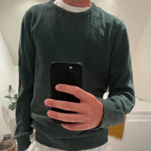 Mörkgrön stickad tröja -  Säljer den här snygga olivgröna tröjan, använd en gång men råkade tvätta den för varmt så den har krympt lite. Passar dig som har M. Inga fläckar eller noppor, riktigt fint skick.  Nypris var 1000 kr – säljer för mycket billigare. Hojta om du är intresserad eller vill ha fler bilder!