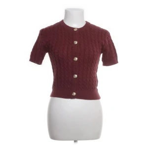 Vinröd kortärmad kofta från H&M - Säljer en vinröd, stickad kofta från H&M med korta ärmar och snygga guldknappar framtill. Jätte mysig kofta inför höstennn