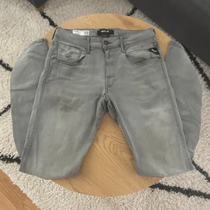 Ljusgråa Replay - Tja👋 Säljer ett par gråa Replay Anbass jeans i klassisk femficksmodell🤩 Jeansen har raka ben, snygga detaljer på bakfickorna och svart patch bak i midjan😮‍💨 Sköna och stilrena byxor som passar till det mesta🔥 Materialet är mjukt och stretchigt för extra komfort👖  Storleken är W33(38cm) L32(106cm)📏  Vid frågor: Meddela oss📩