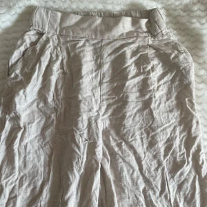Linnebyxor  - Beiga, vida linnebyxor med fickor framtill, köpa på H&M och i storlek 34. Endast använda ett fåtal gånger och i väldigt gott skick. Byxorna behöver dock strykas. 