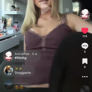 Linnetopp i mörk lila från Miss Milla - Supersöt ribbad linnetopp i mörk lila från Miss Milla. Toppen har spetsdetaljer längs urringningen och tunna axelband. Perfekt att styla med jeans eller kjol för en trendig look.