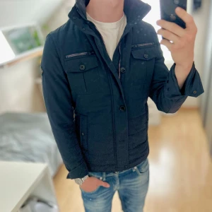 J.lindeberg Field Jacket - Mycket fint skick, en knapp saknas men inget man tänker på. Storlek S passar dig som är mellan 178-188cm. Nypris ca 4000kr.. Modellen är 185 cm, 79 kg. Passar bra nu till sen sommar/höst. Skriv för mer information!🤝