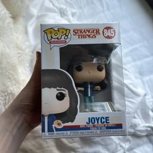 Joyce (Stranger Things) #845 - Cool Funko Pop! vinylfigur av Joyce från Stranger Things. Perfekt för fans av serien som vill ha en unik samlarpryl till hyllan eller skrivbordet. Officiell Netflix-merch, snyggt förpackad och redo att bli en del av din samling! Prisk kan diskuteras!
