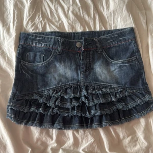 Jeanskjol med volanger🩷🩷 - Säljer en blå jeanskjol med flera lager volanger och utan fickor på rumpan 🩷 midjemått : 40cm rakt över 