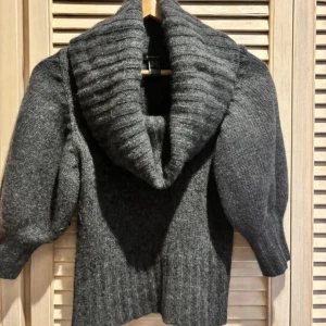 Grå stickad tröja med stor krage Mango - Mysig mörkgrå stickad tröja från Mango med stor, ribbad sjalkrage och trekvartsärmar. Helt slutsåld och i mycket fint skick