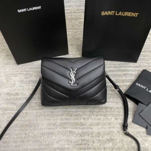 Svart quiltad axelväska från Saint Laurent - Säljer en svart quiltad axelväska från Saint Laurent med ikoniskt YSL-emblem i silver framtill. Väskan är tillverkad i mjukt skinn och har justerbar axelrem, flera fack och dragkedja inuti. Perfekt storlek för det viktigaste och riktigt snygg design.
