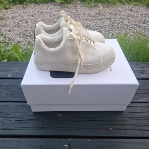 Vita sneakers från Eytys - Snygga vita sneakers från Eytys med chunky sula och klassisk snörning. dem säljs inte längre. Skorna är i skinn med en stilren design och korkinnersula för extra komfort. Perfekta för dig som gillar minimalistisk och trendig stil. Box och extra snören 