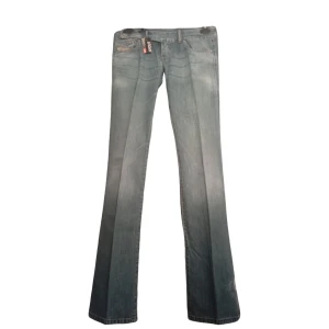 Diesel KYCUT ljusblå bootcut jeans - Snygga ljusblå jeans från Diesel, modell KYCUT. Klassisk femficksdesign med bootcut-ben och låg midja. Jeansen har slitningar och en tvättad look, tillverkade i mjukt denim. Perfekta för dig som gillar en avslappnad och trendig stil. Aldrig använda