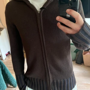 Bryn stickad zip från Tiger of Sweden - Säljer en brun stickad kofta från Tiger of Sweden i 100% bomull. Tröjan är i nyskick och passar M-L