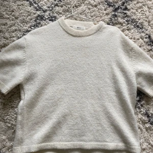 Vit stickad kortärmad tröja  - Stickad kortärmad tröja från gina i storlek xs. Enkel och stilren design som passar till allt.