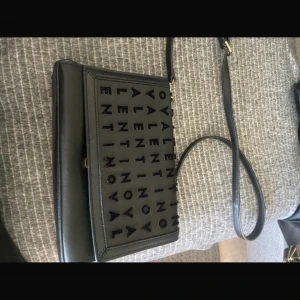 Svart axelväska från Valentino - Snygg svart axelväska från Valentino med logotyp i sammet på framsidan..