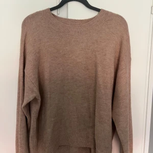 Beige stickad tröja från H&M - Mysig beige stickad tröja från H&M i storlek L. Tröjan har rund halsringning, långa ärmar och en avslappnad passform. Perfekt för lager-på-lager och chill dagar. Enkel och stilren design som funkar till det mesta.