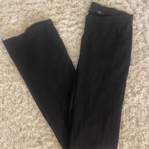 Svarta bootcut  - Byxorna har en stilren look och är perfekta för en clean och enkel outfit. Materialet känns mjukt och följsamt, vilket gör dem bekväma att bära hela dagen.