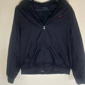 Ralph Lauren vindjacka  - Tjena, säljer nu min mörkblå Ralph lauren vindjacka. Storlek ungdom XL vilket motsvarar herr S. Passar perfekt till dig som är mellan 160-165 cm men kan även passa kortare/längre. Skriv om ni har några frågor eller vill ha mer bilder 😊