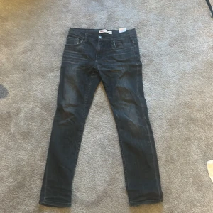 Mörkblå Levis jeans - Säljer ett par mörkblå Levis jeans med klassisk femficksdesign och raka ben. Jeansen har subtila slitningar framtill för en snygg vardagslook. Passar perfekt till både sneakers och boots.