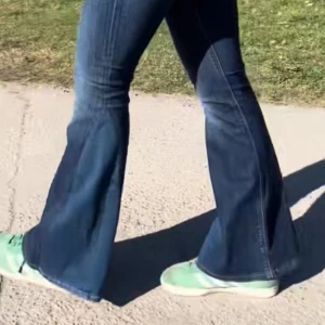 Blå bootcut jeans med broderade fickor - Säljer ett par klassiska blå bootcut jeans från Replay med snygga broderade detaljer på bakfickorna. Jeansen har normal passform och är tillverkade i ett mjukt denimtyg med lätt stretch. Perfekta för dig som gillar en retroinspirerad look. Lågmidjade!! Jeansen är omsydda från skinny till bootcut! 